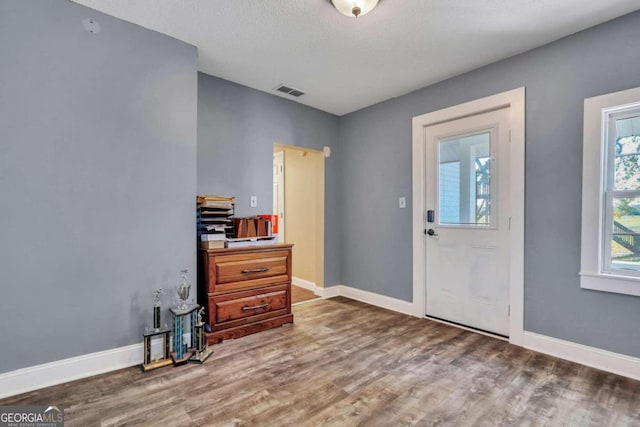 foyer with wood-type flooring and a textured ceiling