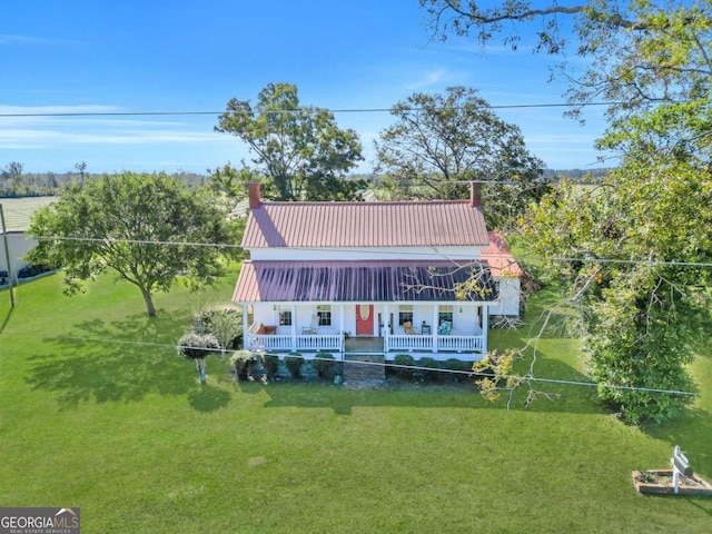 rear view of house featuring a lawn and a porch