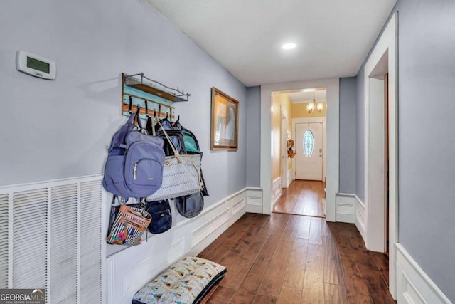 doorway to outside featuring dark hardwood / wood-style flooring and a notable chandelier