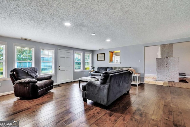 living room featuring a textured ceiling and dark hardwood / wood-style floors