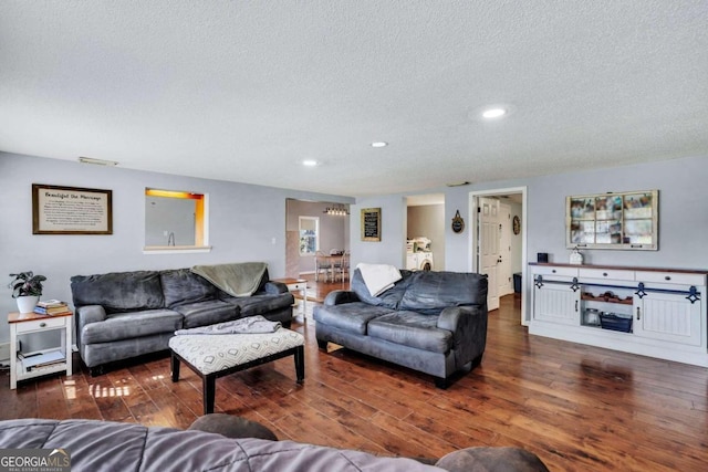 living room featuring dark hardwood / wood-style floors and a textured ceiling