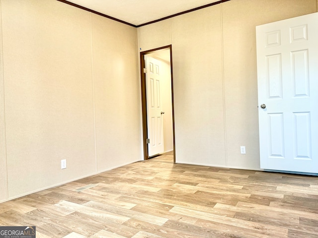 spare room with light hardwood / wood-style flooring and ornamental molding