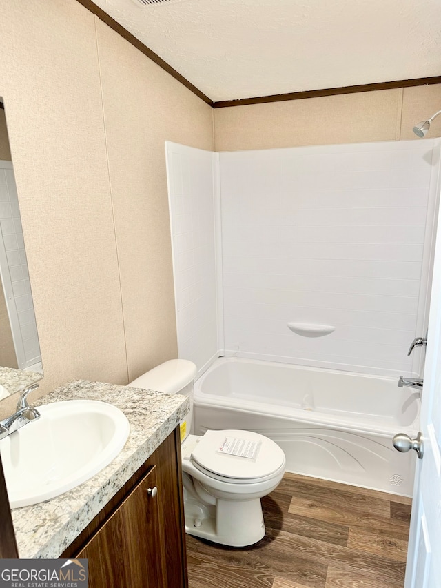 full bathroom featuring vanity,  shower combination, crown molding, hardwood / wood-style flooring, and toilet