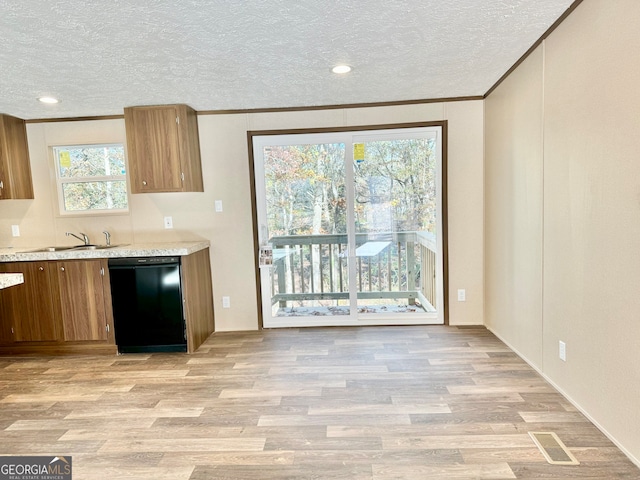 kitchen with light hardwood / wood-style floors, a textured ceiling, and black dishwasher