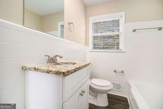 bathroom with vanity, toilet, wood-type flooring, and tile walls