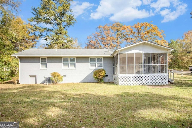 rear view of property with central air condition unit, a lawn, and a sunroom