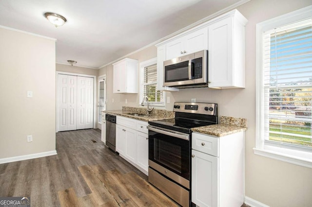 kitchen featuring stainless steel appliances, white cabinetry, a wealth of natural light, and sink