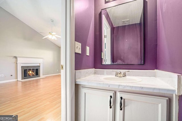 bathroom featuring hardwood / wood-style flooring, vanity, ceiling fan, and lofted ceiling