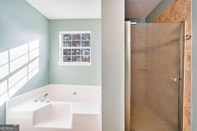 bathroom with shower with separate bathtub and a textured ceiling