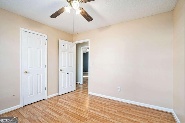 unfurnished bedroom featuring ceiling fan, light hardwood / wood-style flooring, and a textured ceiling