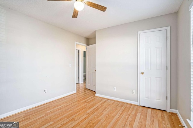 unfurnished bedroom with ceiling fan, light hardwood / wood-style flooring, and a textured ceiling