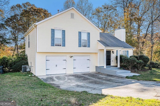 view of front of property featuring central air condition unit, a front yard, and a garage