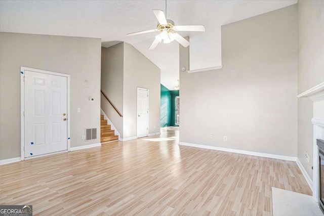 unfurnished living room with a textured ceiling, light hardwood / wood-style floors, high vaulted ceiling, and ceiling fan