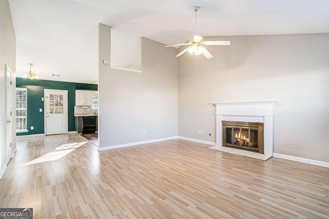 unfurnished living room featuring ceiling fan, light wood-type flooring, and high vaulted ceiling