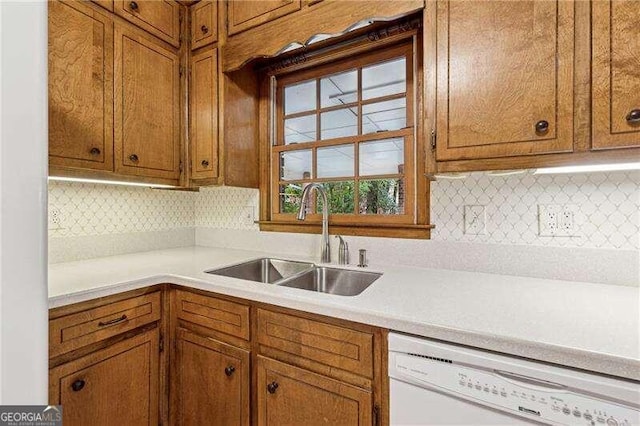 kitchen featuring dishwasher, decorative backsplash, and sink