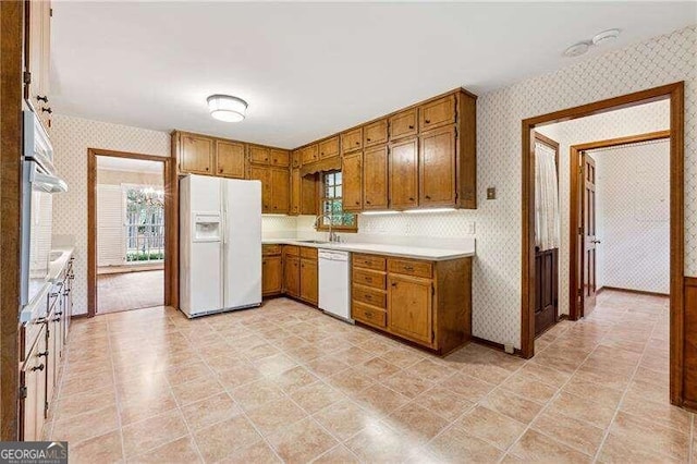 kitchen featuring white appliances and sink