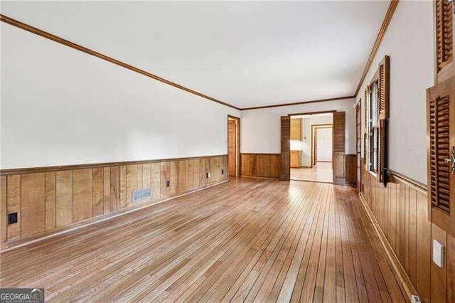 interior space featuring light wood-type flooring and ornamental molding