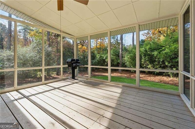 unfurnished sunroom featuring ceiling fan