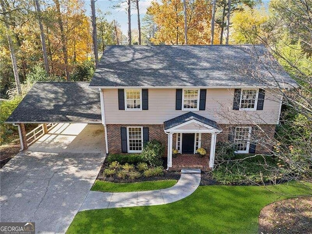 colonial house with a front yard and a carport