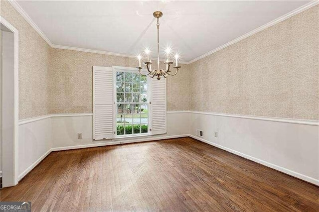 unfurnished dining area featuring hardwood / wood-style floors, ornamental molding, and a chandelier