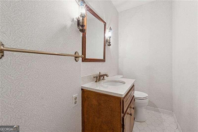 bathroom featuring tile patterned flooring, vanity, and toilet