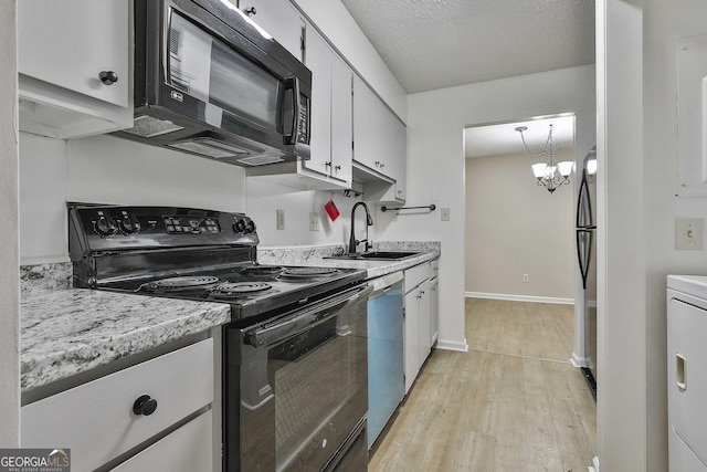 kitchen with light hardwood / wood-style floors, black appliances, sink, an inviting chandelier, and white cabinetry