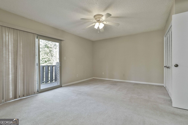 carpeted empty room with ceiling fan and a textured ceiling