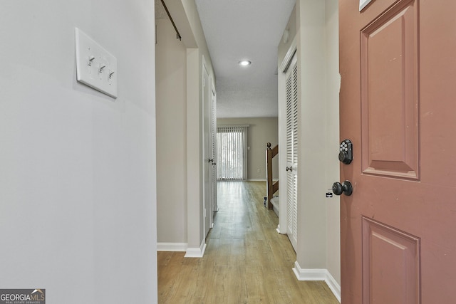 hallway with light hardwood / wood-style floors