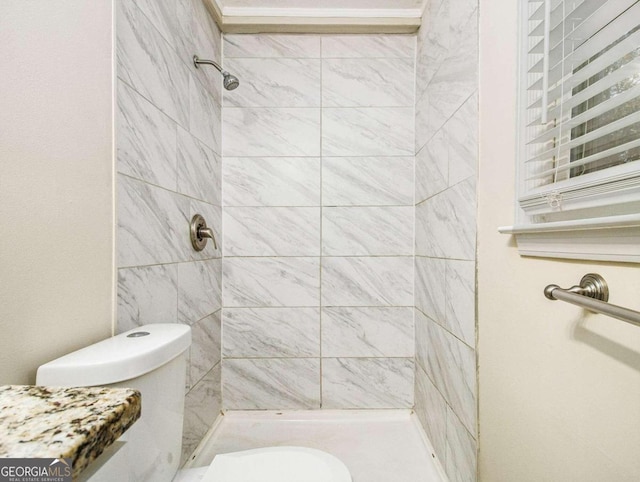 bathroom with toilet and tiled shower