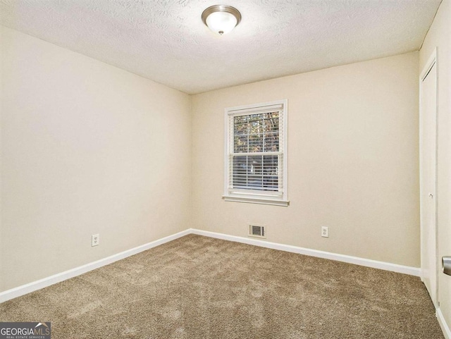 unfurnished room featuring carpet floors and a textured ceiling