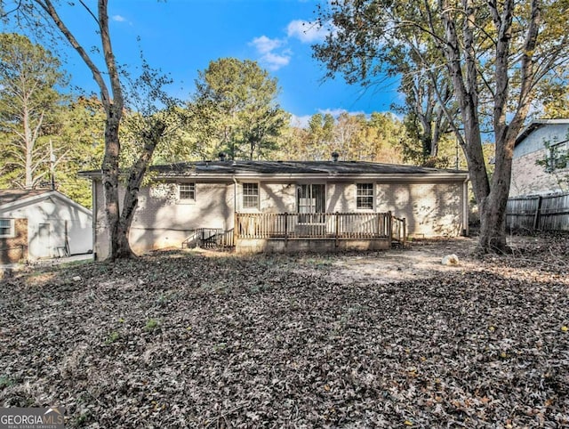 back of property with a storage unit and a deck