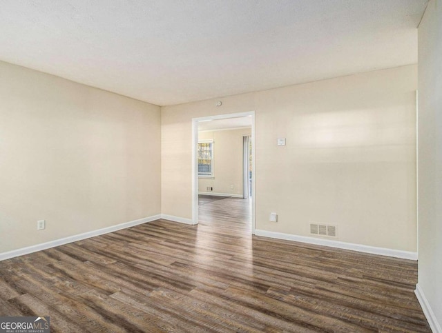 unfurnished room with dark hardwood / wood-style floors and a textured ceiling