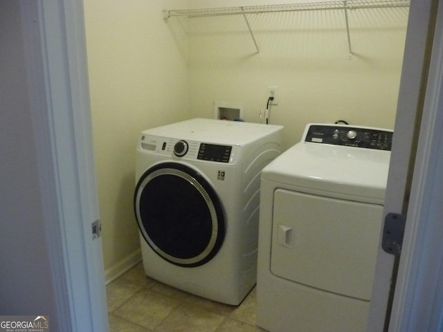 laundry room featuring washing machine and dryer and light tile patterned floors