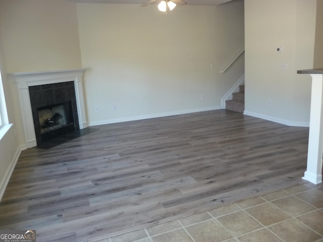 unfurnished living room with a fireplace, ceiling fan, and hardwood / wood-style flooring