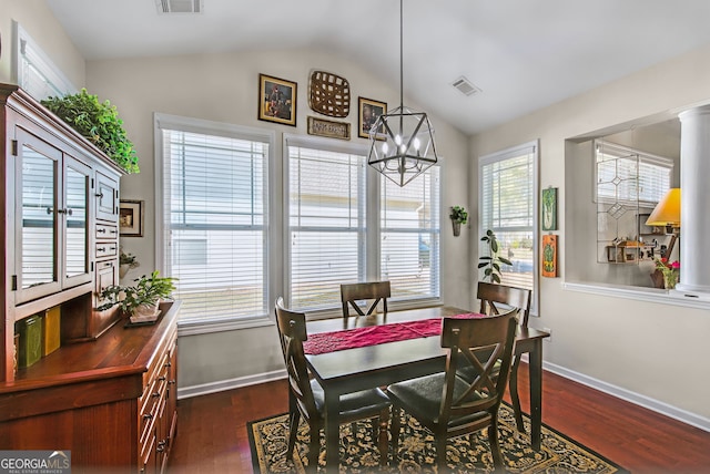 dining room featuring dark hardwood / wood-style flooring, ornate columns, lofted ceiling, and a notable chandelier