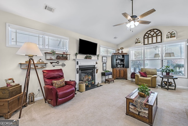 carpeted living room with ceiling fan and vaulted ceiling