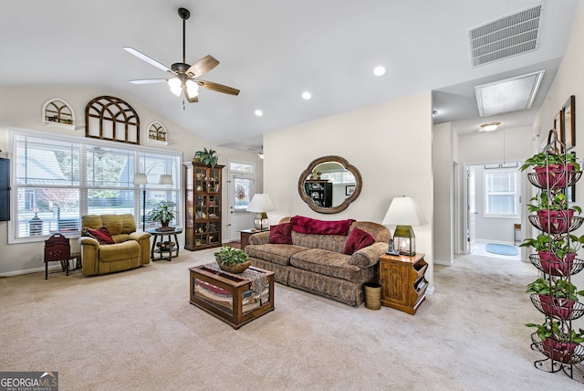 living room with ceiling fan, plenty of natural light, high vaulted ceiling, and light carpet