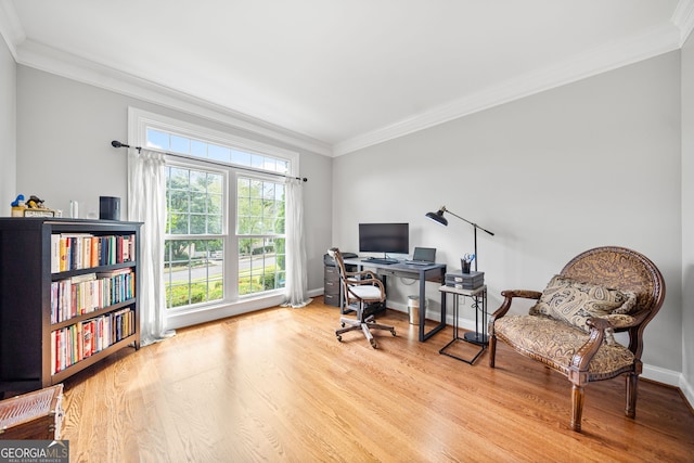 home office with light wood-type flooring and ornamental molding