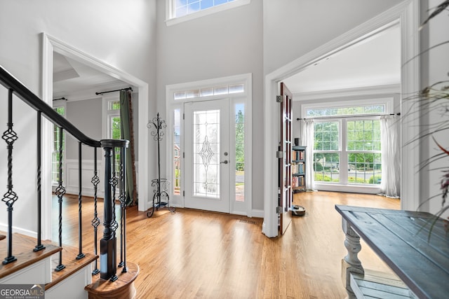 foyer featuring plenty of natural light, light wood-type flooring, and a towering ceiling