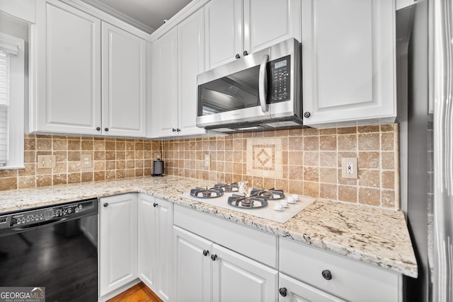 kitchen featuring decorative backsplash, stainless steel appliances, white cabinetry, and light stone counters