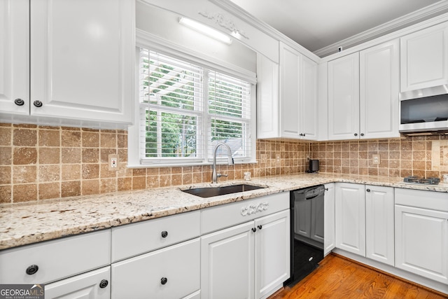 kitchen with sink, light wood-type flooring, appliances with stainless steel finishes, light stone counters, and white cabinetry