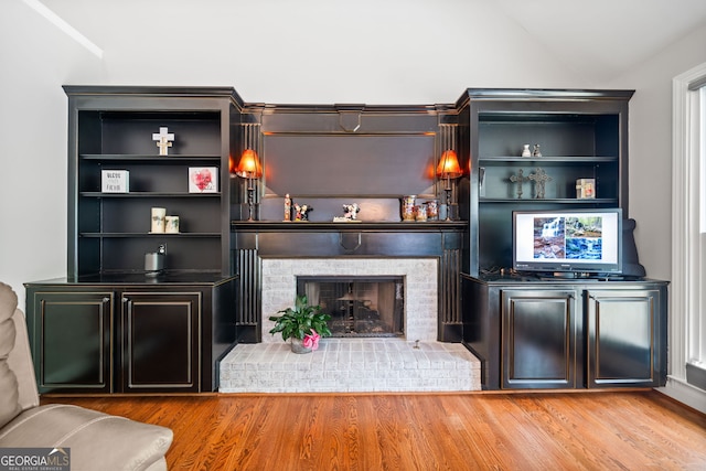 bar with a fireplace, pendant lighting, and light hardwood / wood-style floors