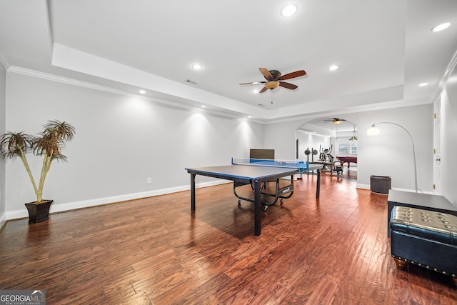 rec room with hardwood / wood-style flooring, a raised ceiling, ceiling fan, and ornamental molding