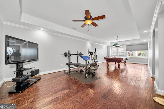 exercise room with a raised ceiling, ceiling fan, crown molding, hardwood / wood-style flooring, and billiards