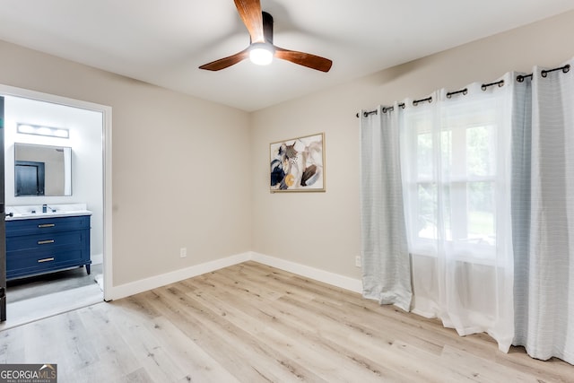 unfurnished bedroom featuring ensuite bathroom, ceiling fan, and light wood-type flooring