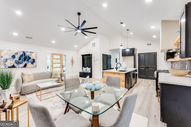 living room with light wood-type flooring, high vaulted ceiling, ceiling fan, and sink