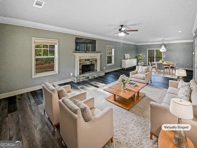 living room featuring a stone fireplace, ceiling fan, ornamental molding, and hardwood / wood-style flooring