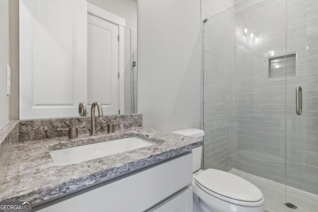 bathroom featuring walk in shower, vanity, and toilet