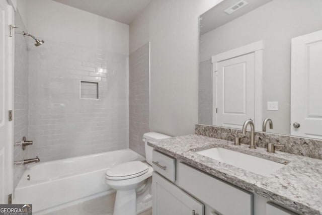 full bathroom with toilet, vanity, and tiled shower / bath combo