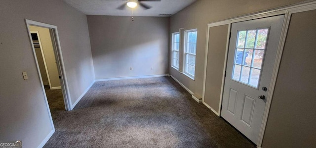 foyer featuring ceiling fan and dark colored carpet